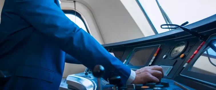 Person in a suit operating a control panel in a modern cockpit with vibrant background.