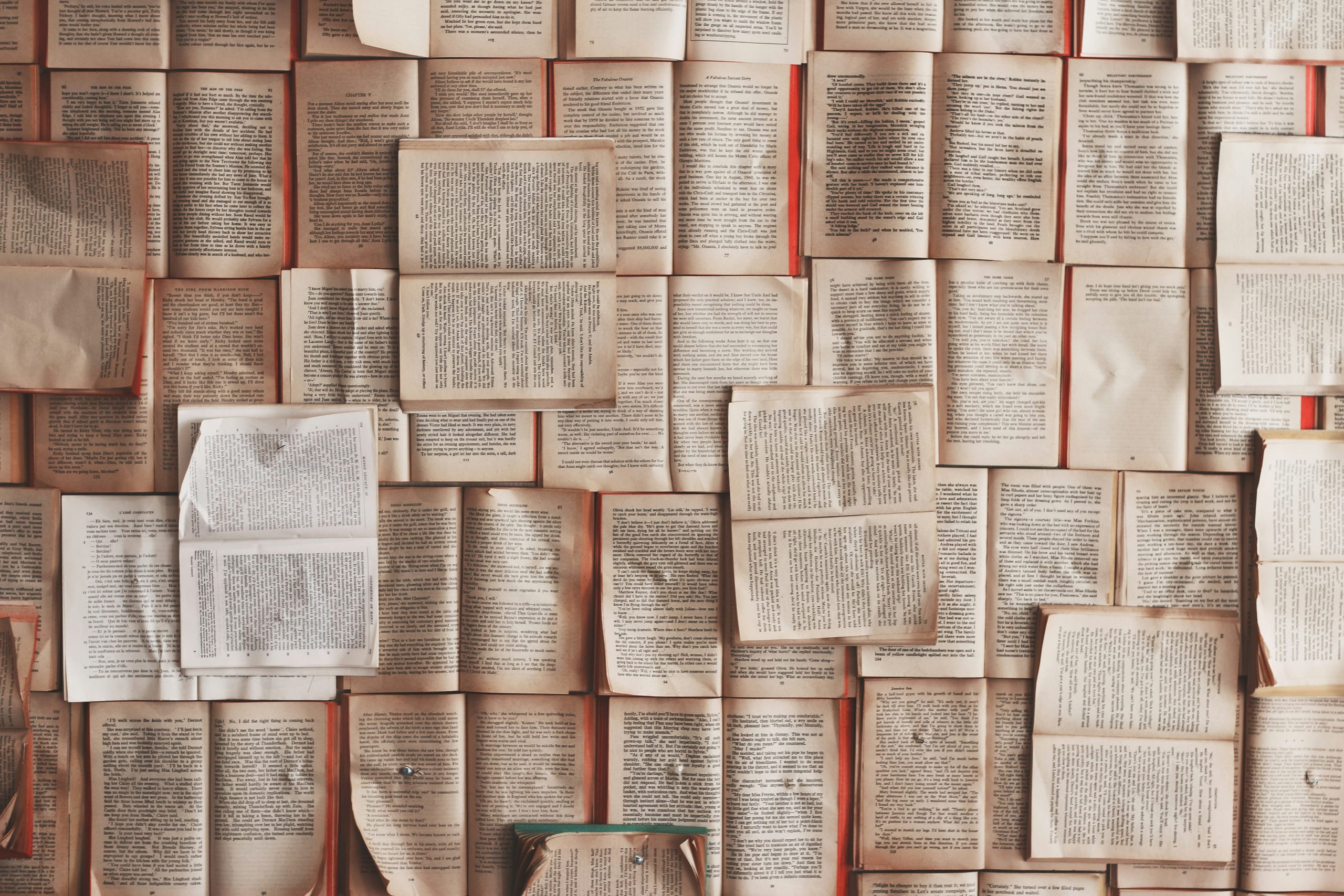 A collage of open books showcasing text-filled pages with a vintage aesthetic.