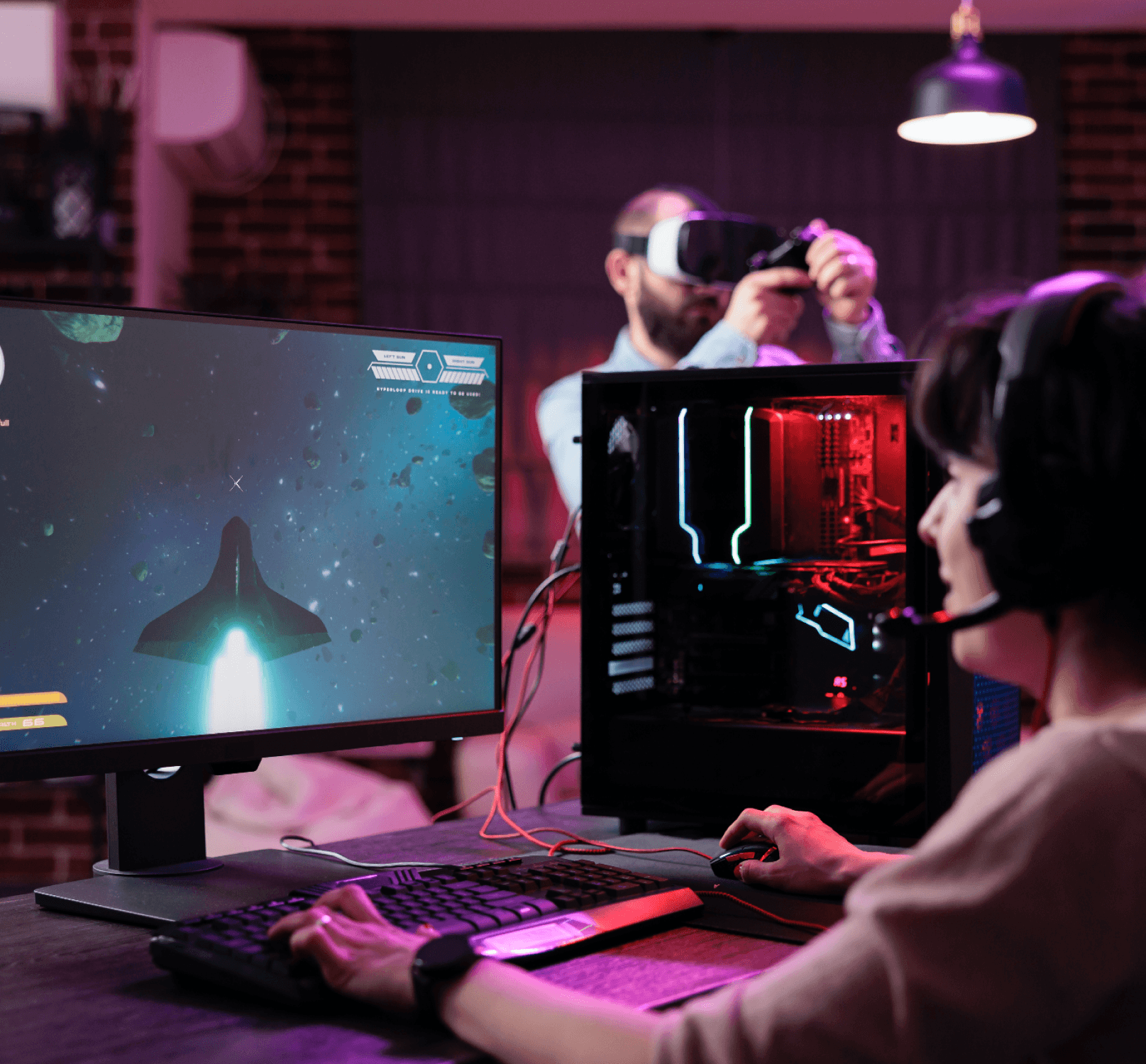Osoba grająca na PC z zestawem VR, kolorowy zestaw komputerowy i wizualizacje o tematyce kosmicznej.