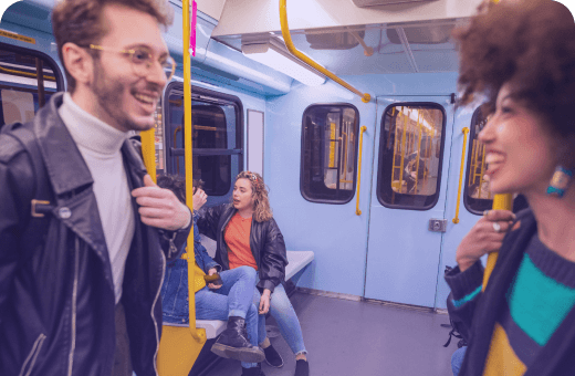 Young adults enjoying a lively conversation on a colorful subway train.