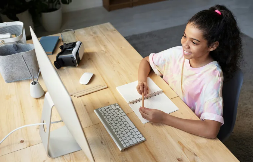 Giovane utente Moodle con maglietta rosa che guarda un corso con ReadSpeaker e Brickfield combinati per l'accessibilità didattica