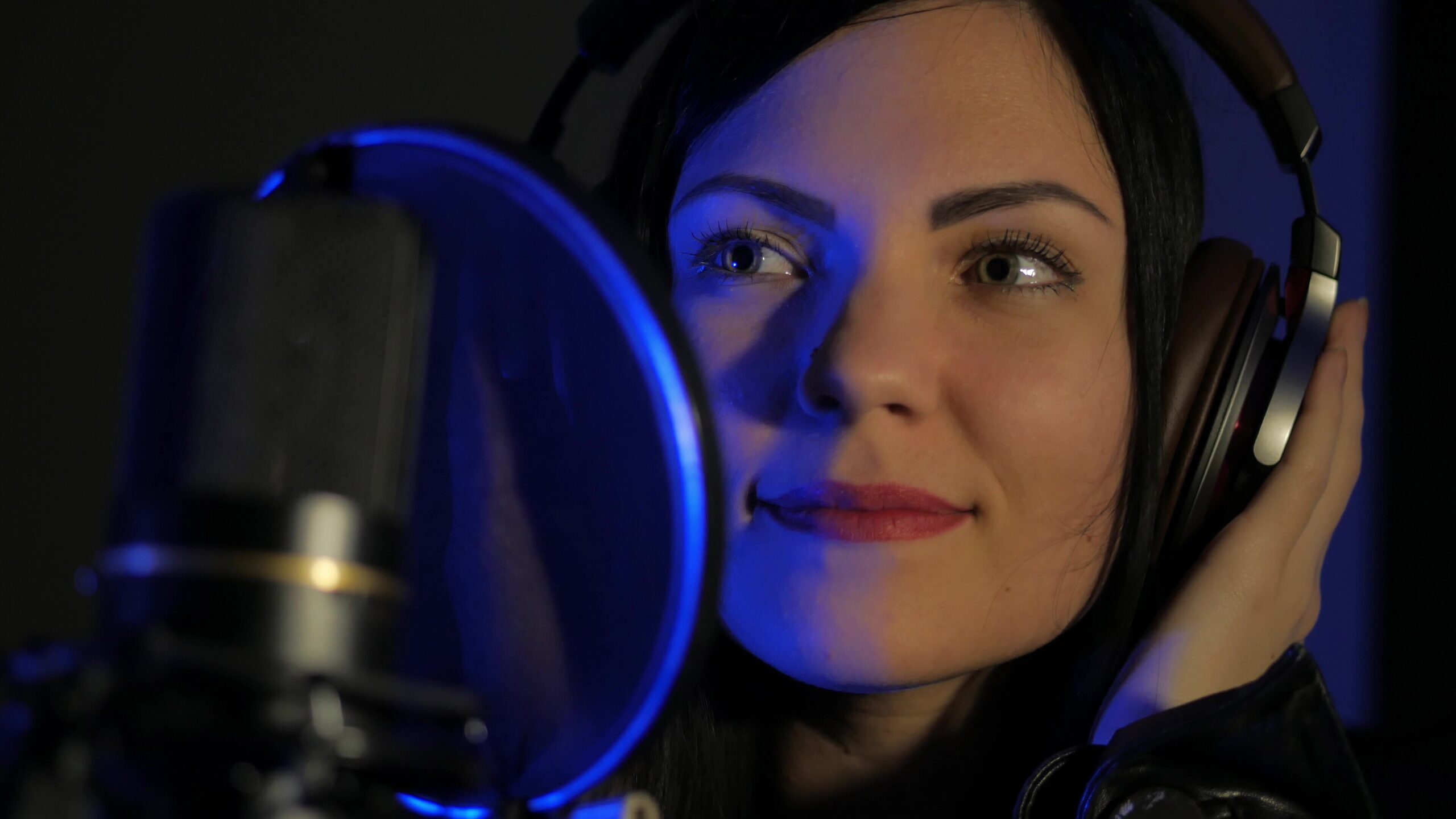 Woman with headphones in recording studio.