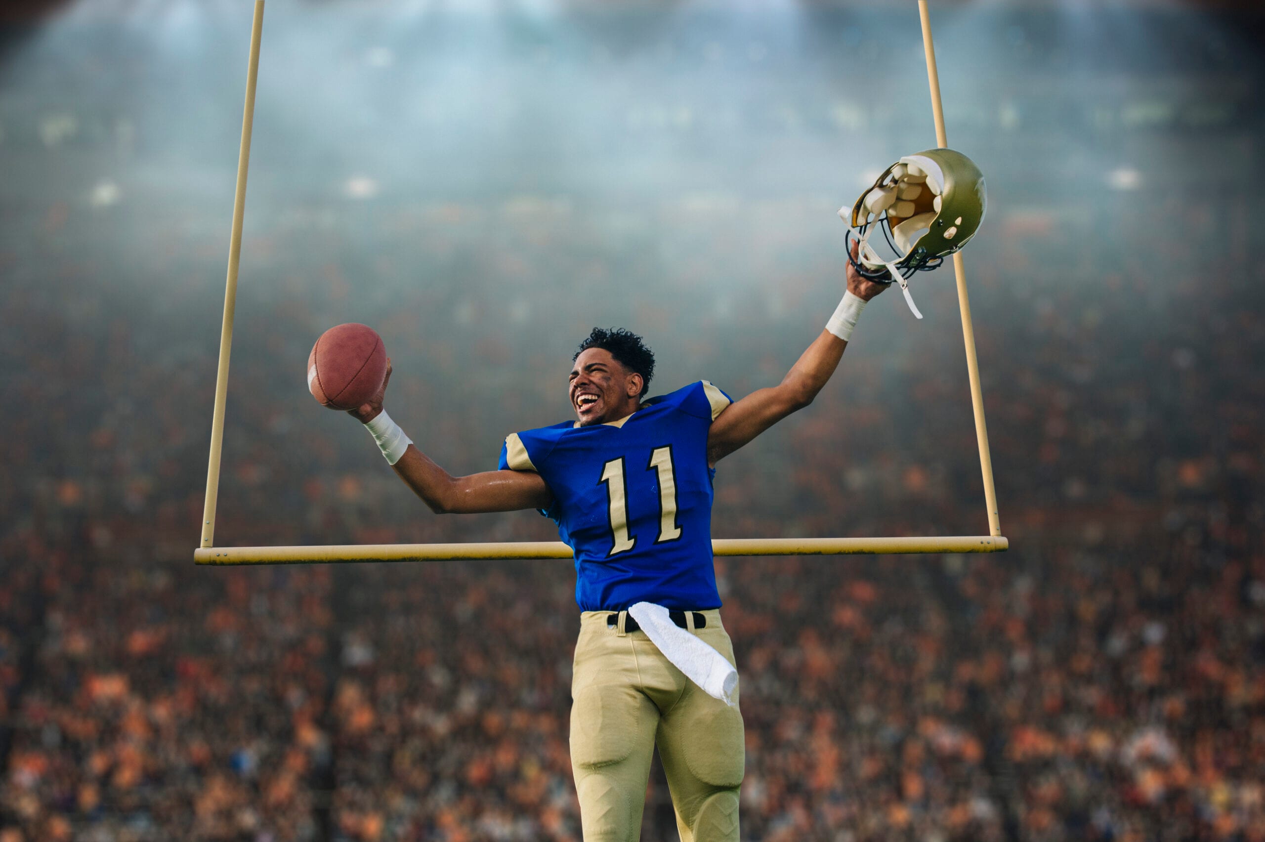 Teenage American football player celebrating victory in stadium.