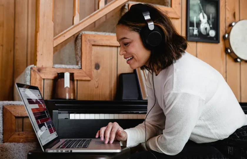Une femme portant un casque audio utilise un ordinateur portable.