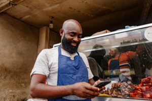 Un homme en tablier regarde un smartphone